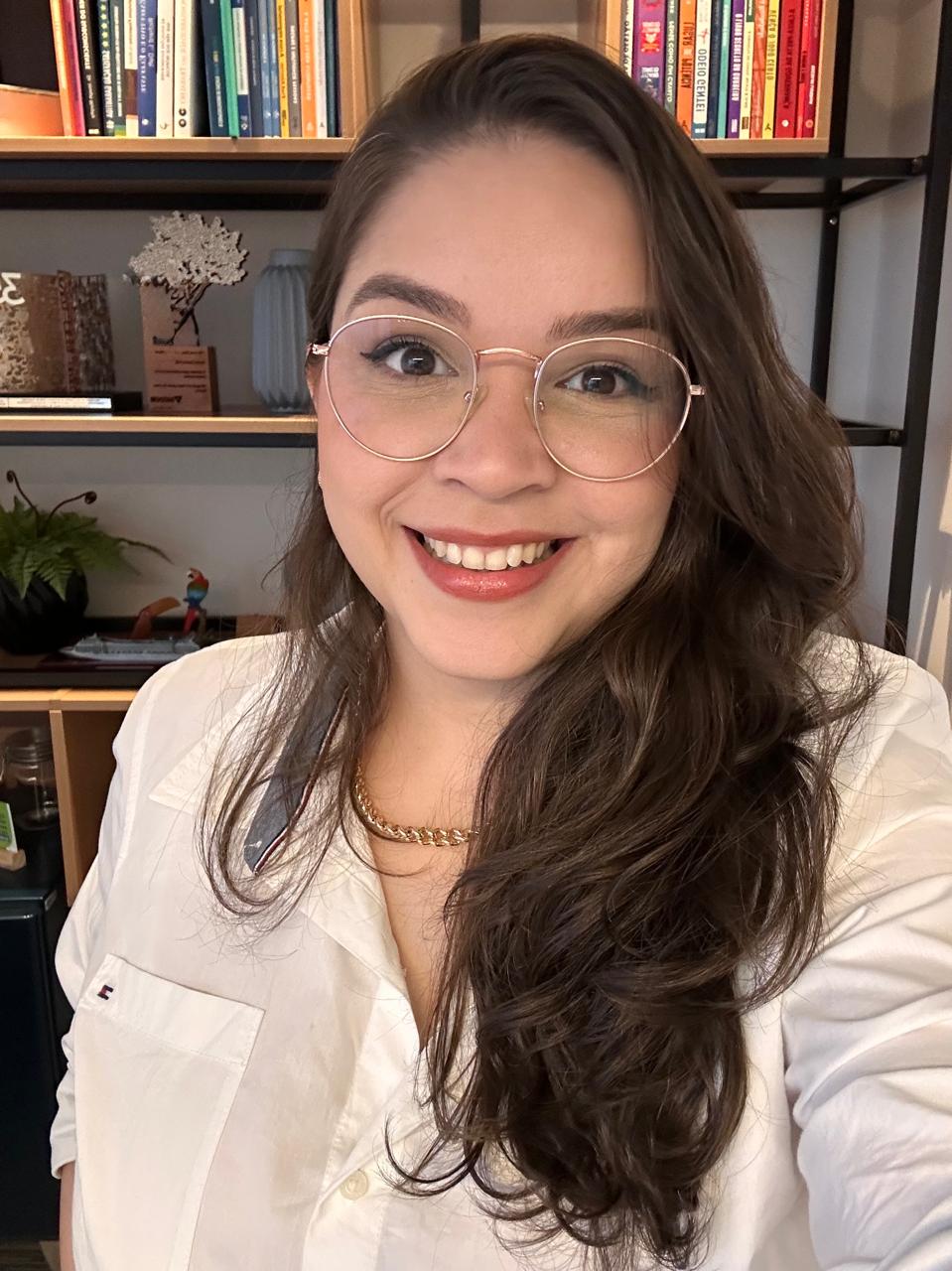 Foto da autora do eBook, Gestora Sincera, sorrindo e usando óculos